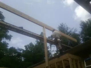 Carpenter setting a ridge beam over a new addition frame — Ice Dam Removal by Roofing Brothers in Yellow Springs