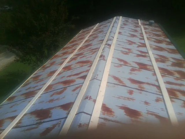 Rusted metal roof panels with new wood purlins before replacement — Storm Damage Roof Repair in Yellow Springs by Roofing Brothers