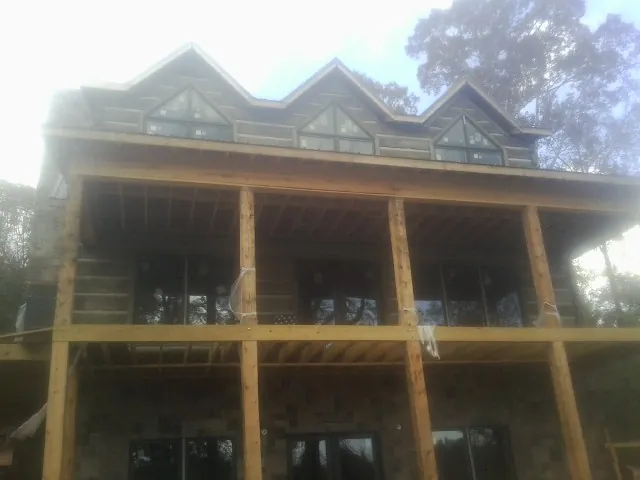 Dormers and porch framing on a large log home under construction — Roof Coating work by our crew in Yellow Springs