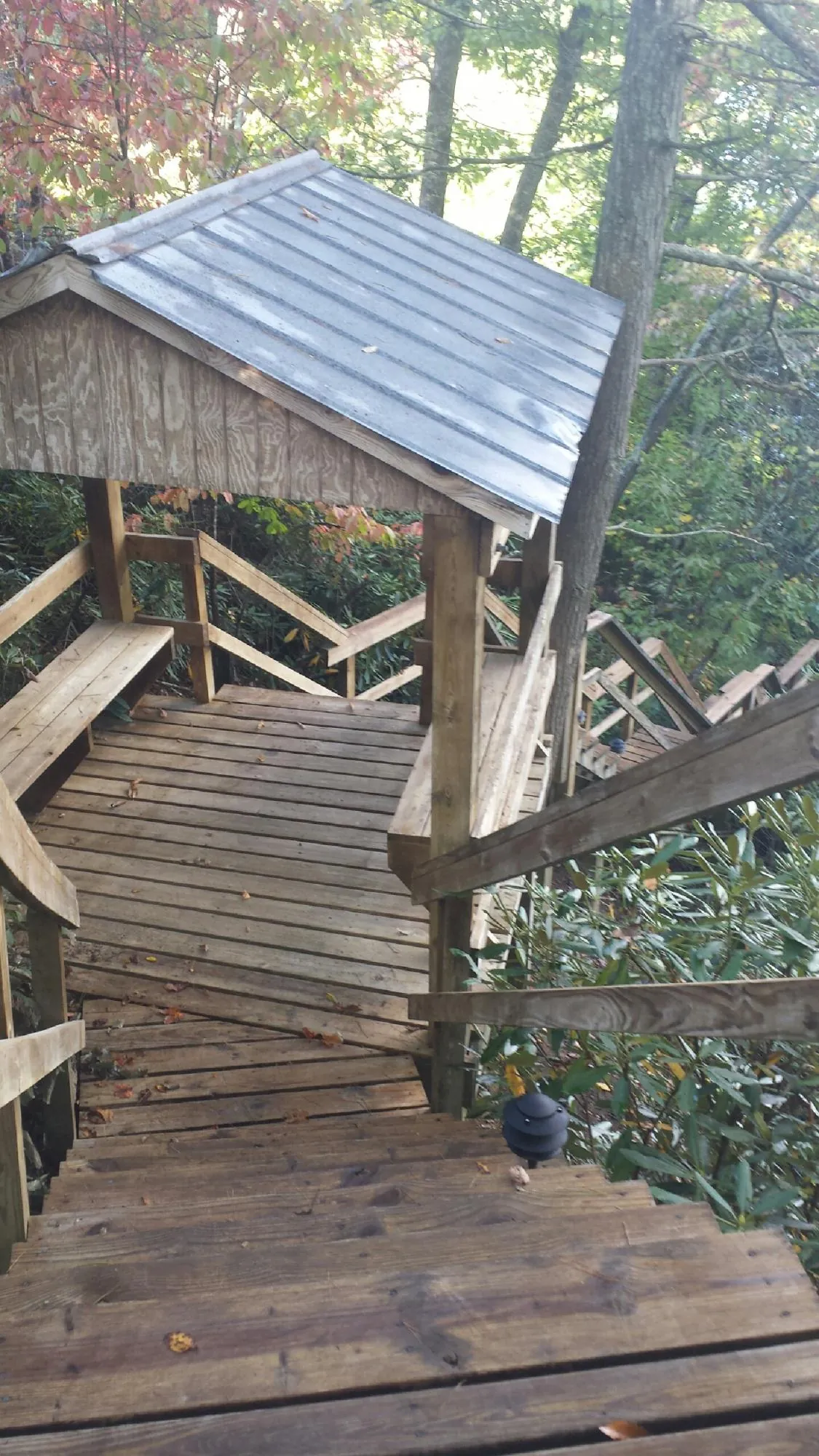 Metal roofed shelter over wooden steps on a wooded walkway — Skylight Repair & Installation work by our crew in Yellow Springs
