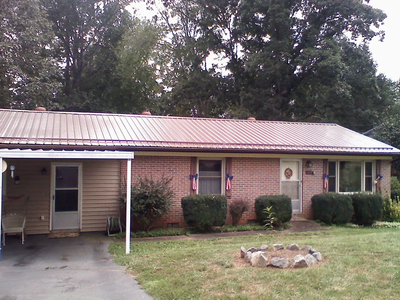 Bronze metal roof and carport on a brick ranch home — Roof Repair work by our crew in Yellow Springs